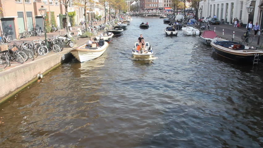 LEIDEN, HOLLAND - SEPTEMBER 24: People sail in a boat in a canal on September 24, 2011, Leiden, Holland. Leiden is the second largest 17th century town centre in the Netherlands. - HD stock video clip