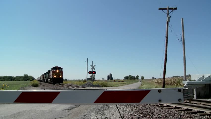 A Freight Train Speeds Past A Gated Railroad Crossing. - Hd Stock Video 