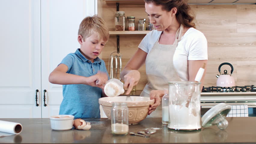 Mother And Daughter Making A Cake With A Mess Mother And Daughter Making A Cake With A Mess