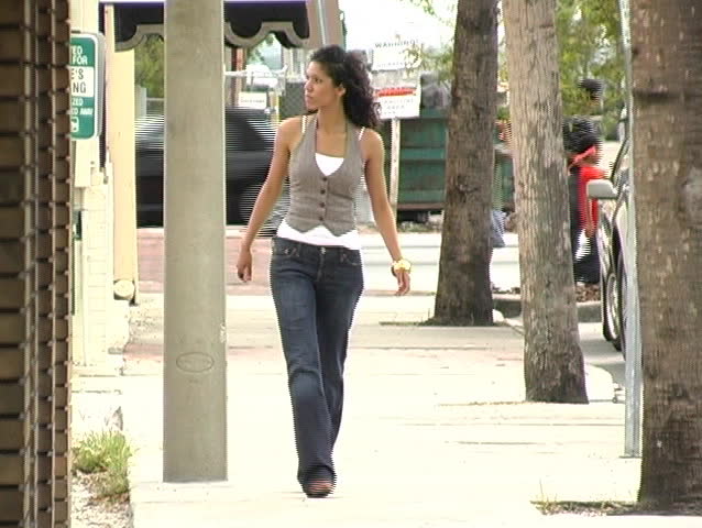 A Beautiful Latina Brunette Walks Toward The Camera On A Downtown Sidewalk Full Length Stock