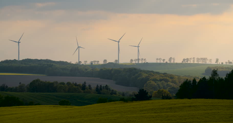 4K Beautiful windmill turbines, wind energy silhouetted in the sunset 