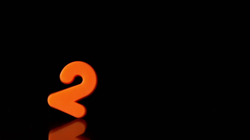 Orange Number Two Falling On Black Background In Slow Motion Stock