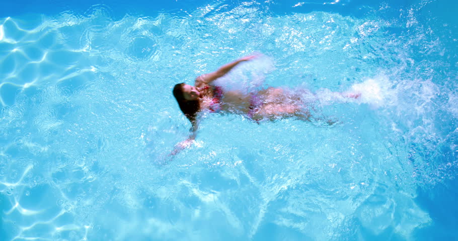 Overhead Of Brunette Swimming In Pool On Sunny Day On Her