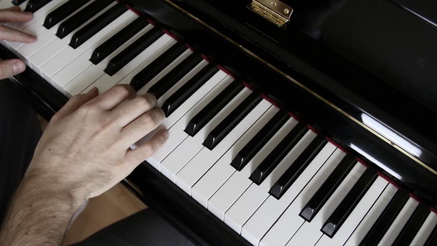 A Beautiful Shot Of A Man Playing A Song On A Black And White Piano