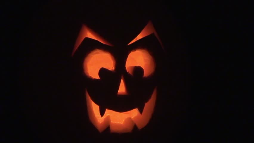 Two Candle-lit, Carved Pumpkin Jack-o'-lanterns Sit Side By Side With 