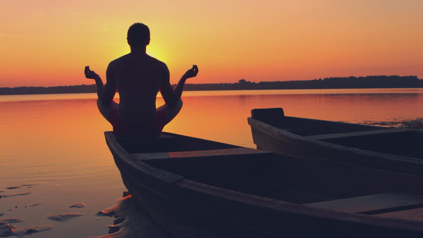 Boy Does Yoga Exercises In A Field At Sunrise. Silhouettes Stock ...