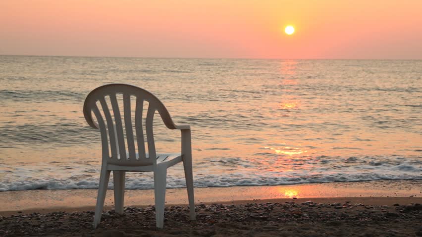 One White Plastic Chair There Is On Beach In Front Of Sea At Sunset ...