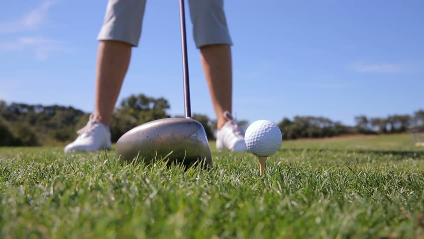 Close Up Of A Man Placing A Golf Ball On A Tee And Swinging And Hitting ...