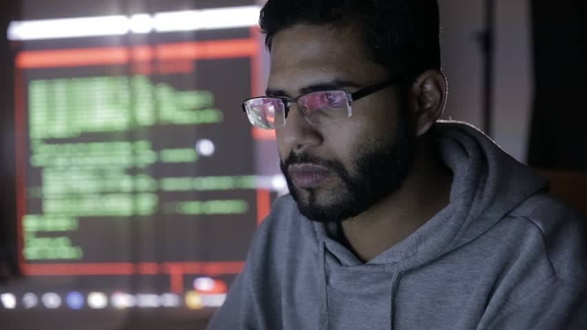 Male Arabic Hacker Hacks Computer In Dark. Computer Code Reflecting On ...