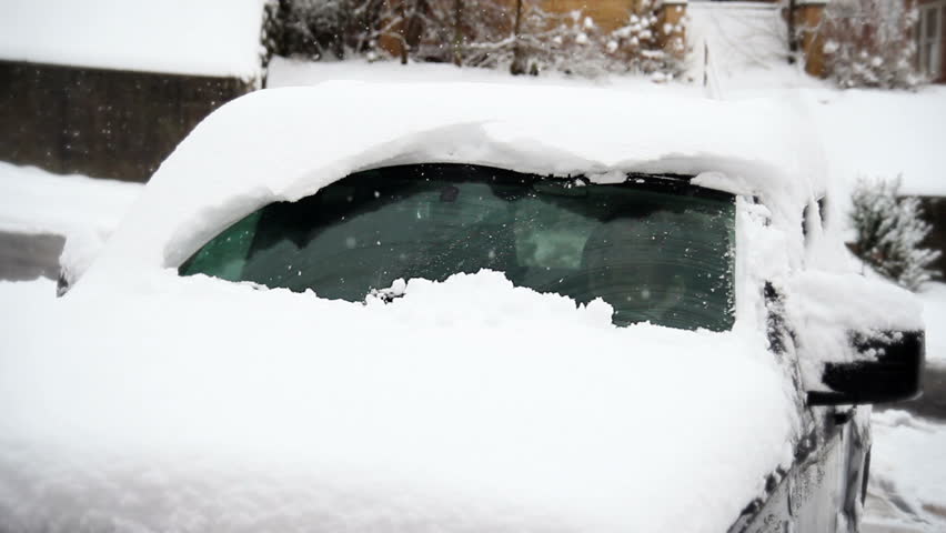 A Car's Windshield Wipers Struggle To Remove The Snow From The ...