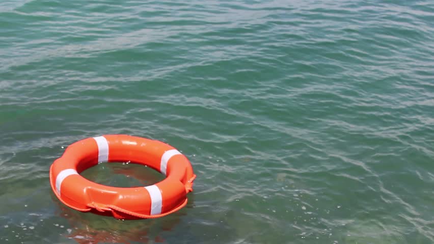 A Red Safe Buoy Being Thrown Into The Water And Floating On It/This Is ...