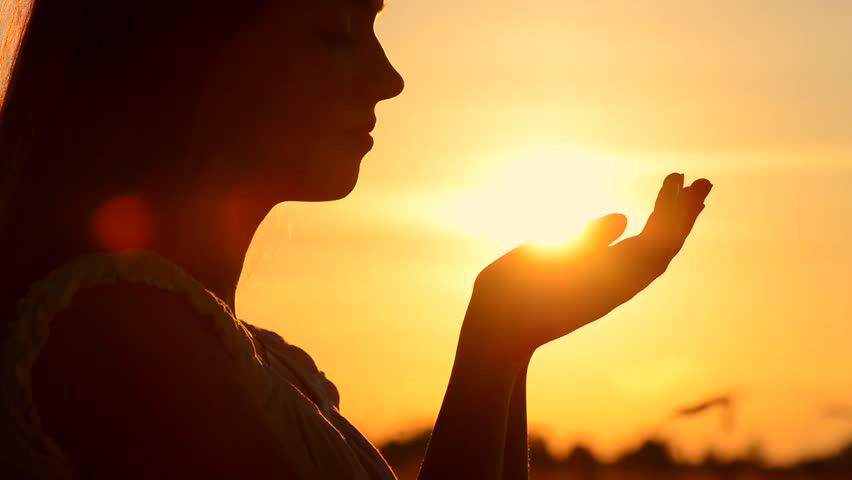 Person Silhouetted Separates Praying Hands To Reveal Sun Shining ...