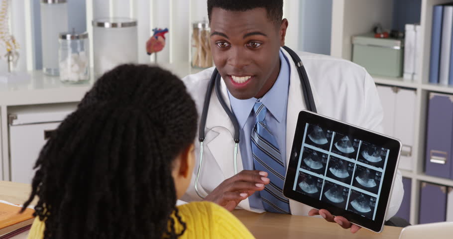 African American Gynecologist Using Tablet To Show Ultrasound To ...