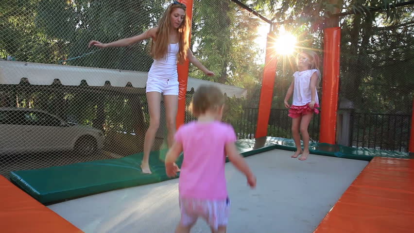 Young Mother With Her Daughter Fun Jumping On The Trampoline. Stock ...